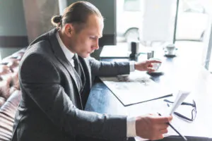 side-view-businessman-checking-document-caf